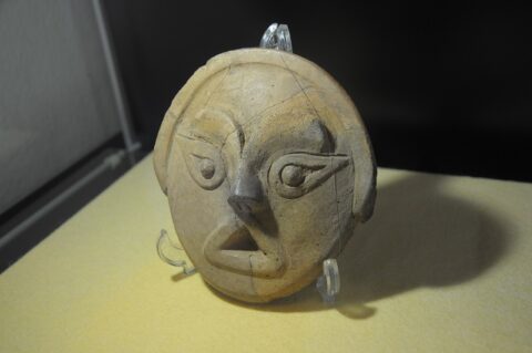 埋蔵文化財調査センターに展示された「丘陵人（おかびと）の肖像」。人の顔のような土面。仮面のようだが、縄文時代の土器に飾りとして貼り付けられていたそう